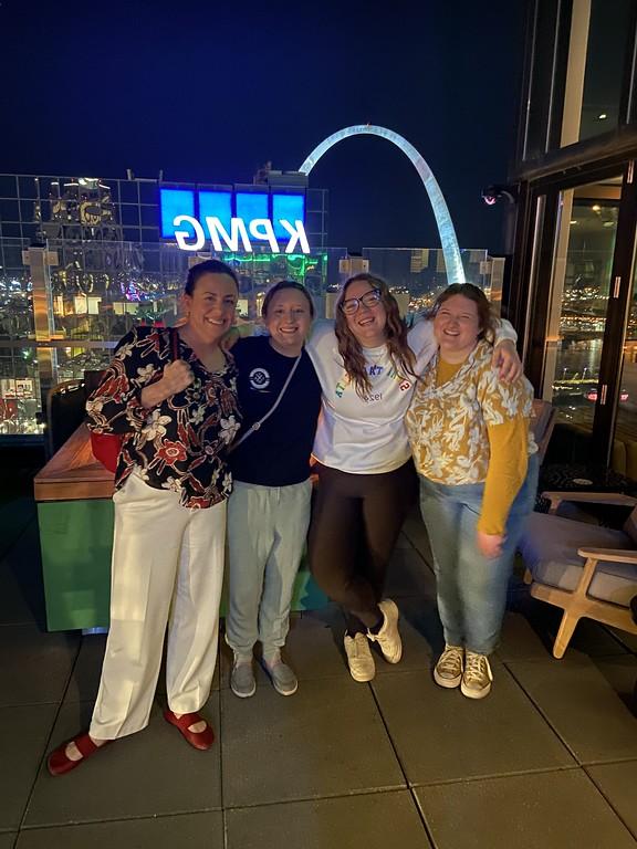 Group of adults posing by the St Louis Arch